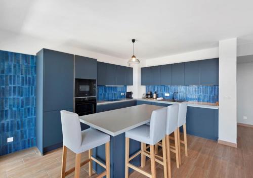 une cuisine avec des armoires bleues et une table et des chaises dans l'établissement Duplex Elegante Vista Panorâmica 360 Juan-les-Pins, à Antibes
