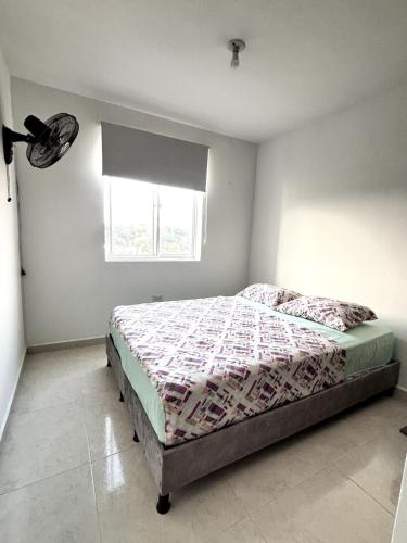 a bedroom with a bed in a room with a window at Apartamento Bucaramanga in Bucaramanga
