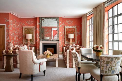 a living room with red walls and a fireplace at The Soho Hotel, Firmdale Hotels in London