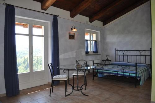 Schlafzimmer mit einem Bett, einem Tisch und Stühlen in der Unterkunft Bricco Rosso in Farigliano