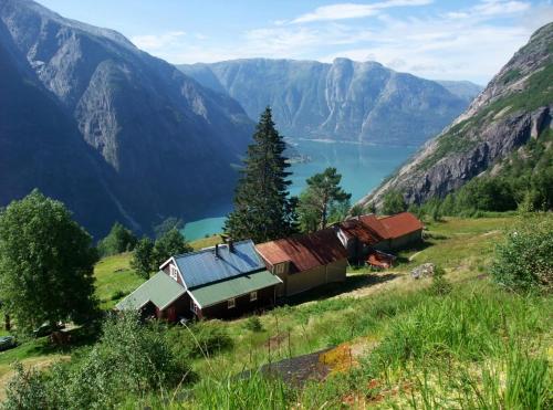 a group of buildings on a hill with a lake and mountains at Eidfjord Fjell in Eidfjord