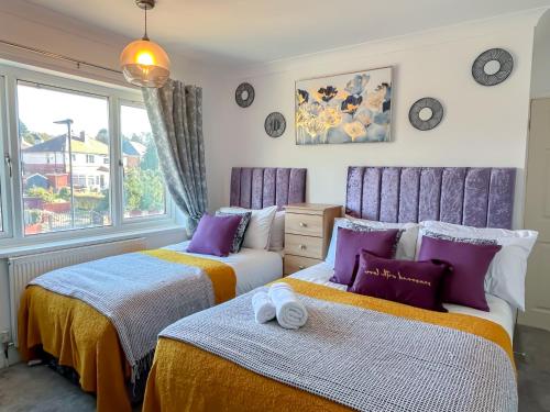 a bedroom with two beds and a window at ColleyHouse-private parking-business-group-relocation-SpaciousStylish 4BRHome-Sleeps 10 in Sheffield