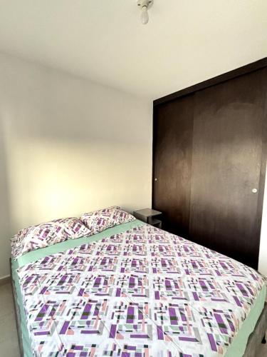 a bedroom with a bed with a wooden headboard at Apartamento Bucaramanga in Bucaramanga