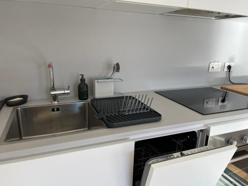 a kitchen sink with a dish drying rack next to it at Casa Gemma in Muggia