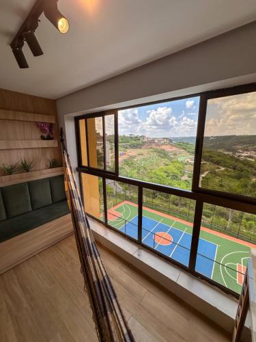 a room with a view of a tennis court from a window at Condomínio Alto da Serra Villas in Bananeiras
