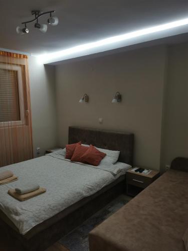 a bedroom with a bed with two pillows on it at Apartmani Manila, Vrnjačke terme-popust, SPA centar Pegaz-popust, garažno mesto in Vrnjačka Banja