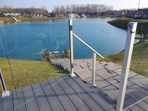 a wooden deck with a view of a lake at Routh 2-Bed Luxury Lodge Hot Tub & Lake View in Routh