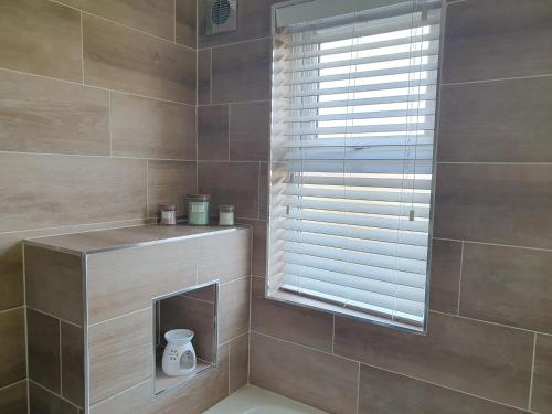 a bathroom with a window with a toilet in it at Routh 2-Bed Luxury Lodge Hot Tub & Lake View in Routh