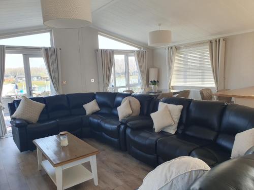 a living room with a blue couch and a table at Routh 2-Bed Luxury Lodge Hot Tub & Lake View in Routh