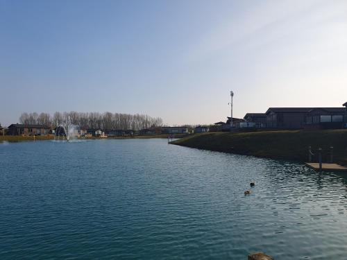 a large lake with ducks in the water at Routh 2-Bed Luxury Lodge Hot Tub & Lake View in Routh