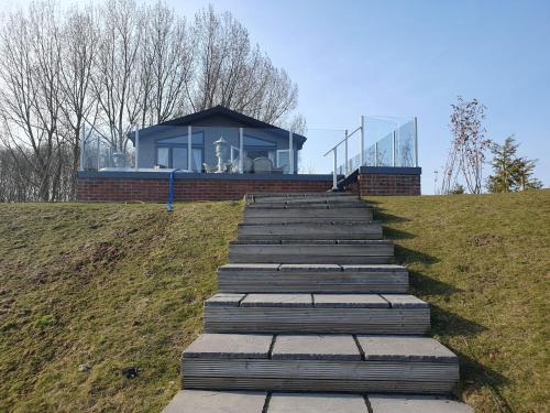 a set of stairs leading up to a house at Routh 2-Bed Luxury Lodge Hot Tub & Lake View in Routh