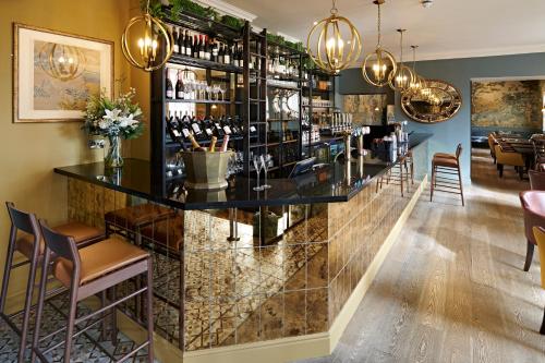 a bar with a black counter and chairs at The Kings Arms in Christchurch