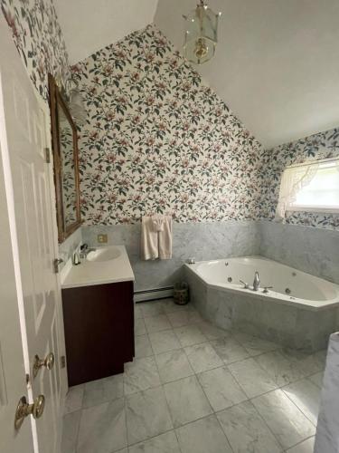 a bathroom with a tub and a sink at Arlington Inn & Spa in Arlington