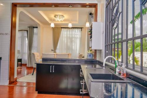 a kitchen with a sink and a large window at Lake duluti serenity villas in Arusha