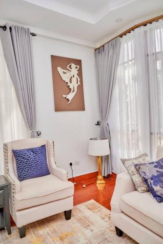a living room with a couch and a chair at Lake duluti serenity villas in Arusha