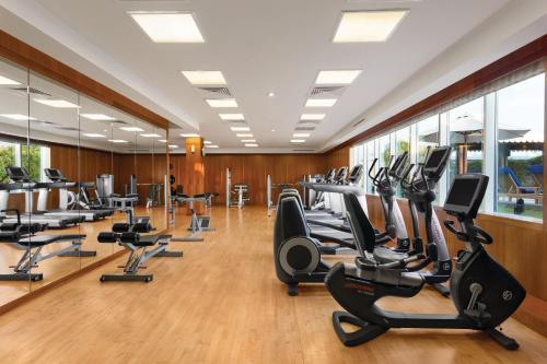 a gym with rows of treadmills and elliptical machines at Crowne Plaza - Dubai Jumeirah by IHG in Dubai