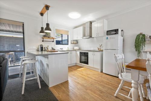 a kitchen with white appliances and a table and chairs at Le Petite in Paynesville