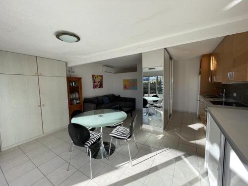 une cuisine et un salon avec une table et des chaises dans l'établissement Villa Port Nature 11 MARILYN - Luxe - 4 personnes, au Cap d'Agde