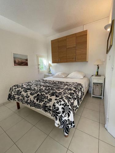 une chambre avec un lit avec une couverture noire et blanche dans l'établissement Villa Port Nature 11 MARILYN - Luxe - 4 personnes, au Cap d'Agde