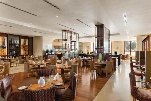 a restaurant with tables and chairs and a bar at Crowne Plaza - Dubai Jumeirah by IHG in Dubai