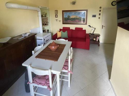 a living room with a table and a red couch at Nido d'Arte in Tirli