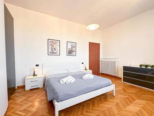 a bedroom with a bed with two towels on it at Vista Ghirlandina - Attico sul tetto del centro al settimo piano in Modena