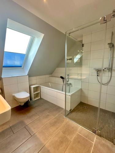a bathroom with a shower and a tub and a toilet at 1310 - Haus Greta in Dahme