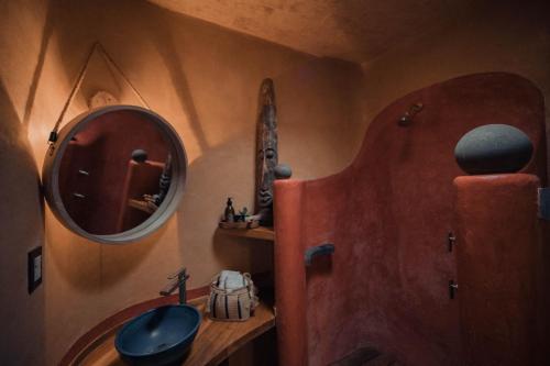 a bathroom with a mirror and a sink at El EQUIMITE HOTEL BOUTIQUE in Coatepec