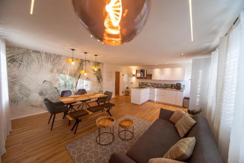 a living room with a couch and a table at P-Hosting Modernes Apartment zwischen Ravensburg und dem Altdörferwald, 110qm, Familienfreundlich, Separater Eingang, Kaffeevollautomat, Bäcker und Pizzeria 15 Meter, Spielplatz 50 Meter, 20 Km zum Bodensee, 30Km in die Berge in Schlier