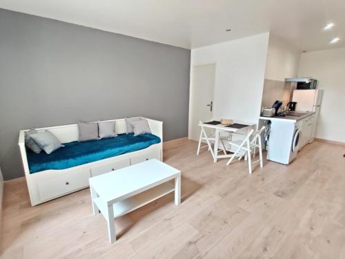 une chambre blanche avec un lit et une table dans l'établissement Le Nid du Pont Neuf, à Pamiers