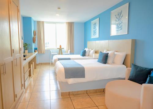 a hotel room with two beds and a couch at Ixchel Beach Hotel in Isla Mujeres