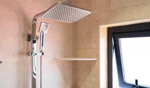a shower in a bathroom with a shower head at CASA GEM in Victoria