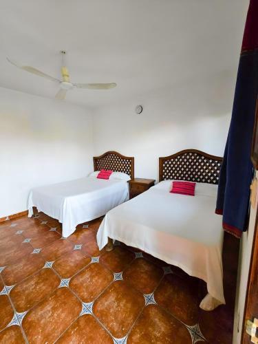 a room with two beds and a tile floor at Hotel Villa Esmeralda in Tuxtla Gutiérrez