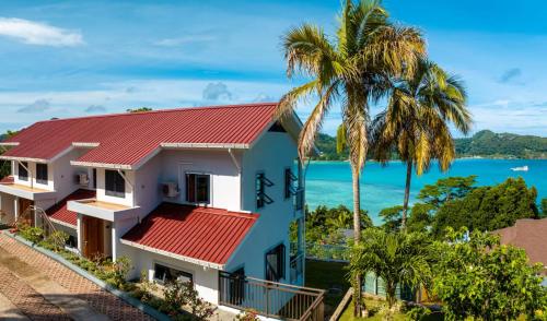 a house with a red roof and a palm tree at CASA GEM in Victoria