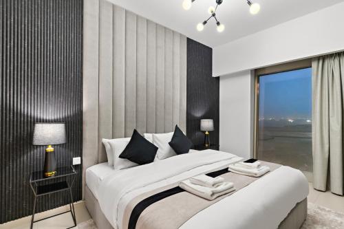a bedroom with a large bed and a window at Desert Key - Platinum Apartments in Gate Tower, Al Reem Island in Abu Dhabi