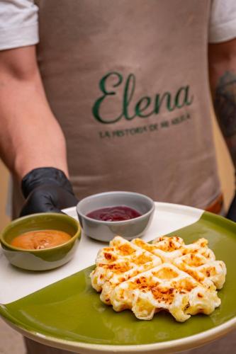 a person standing next to a plate of food at Elena Coffee Hostel Lago Calima Darién in Darién