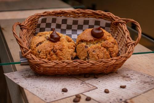 two muffins in a basket on a table at Elena Coffee Hostel Lago Calima Darién in Darién
