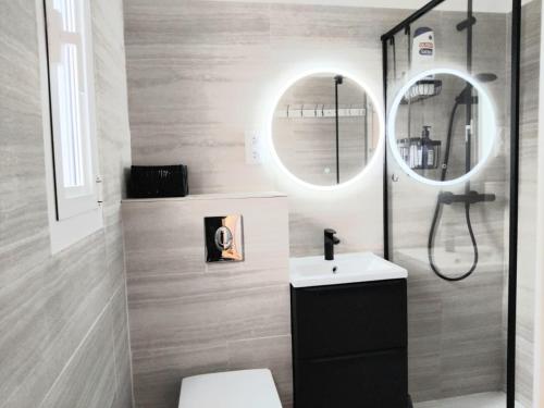 La salle de bains est pourvue de toilettes, d'un lavabo et de deux miroirs. dans l'établissement House with 5 bedrooms and HOT TUB, à Saint Cyprien Plage