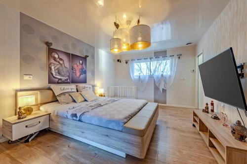 une chambre avec un grand lit et une télévision à écran plat dans l'établissement La Villa Chantalain, à Kerlouan