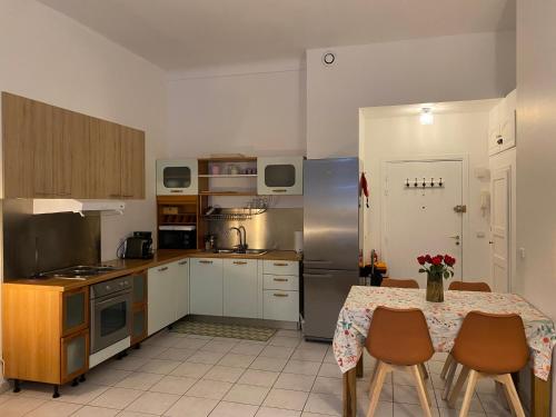 une cuisine avec une table et des chaises et une cuisine avec des placards blancs dans l'établissement The Grand Riviera Apartments Nice - Top Choice in Nice, à Nice