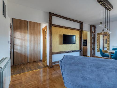 a living room with a blue couch and a tv at The Zlatibor Chalet in Zlatibor