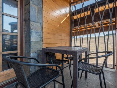 a table and two chairs on a balcony at The Zlatibor Chalet in Zlatibor