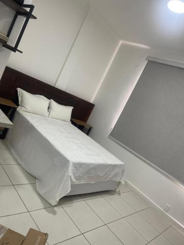 a bedroom with a bed with white sheets and pillows at Condo ipanema 209 in Rio de Janeiro