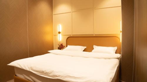 a bedroom with a bed with white sheets and pillows at Arzum in Tashkent