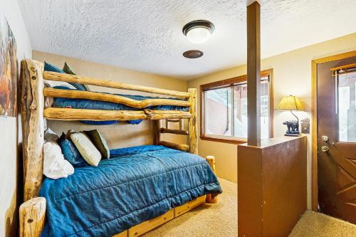 a bedroom with a wooden bunk bed with blue sheets at Stedman Cabin in McCall