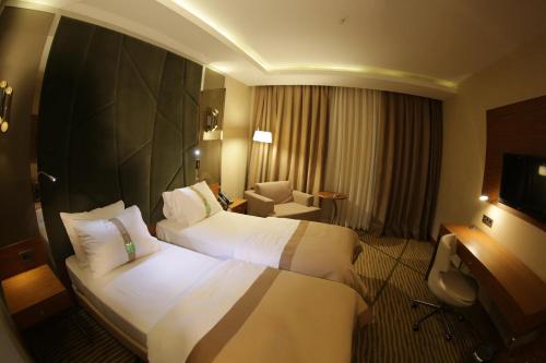 a hotel room with two beds and a chair at Holiday Inn Gaziantep by IHG in Gaziantep