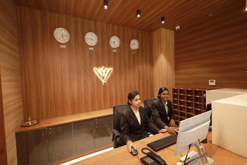 two people sitting at a table with a laptop at Viraj Retreat in Munroe Island