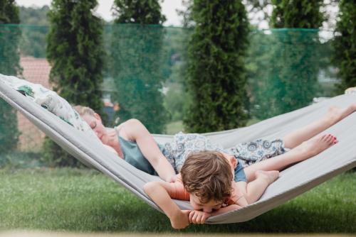 two young children laying in a hammock at Jodłowa Chata in Myślenice