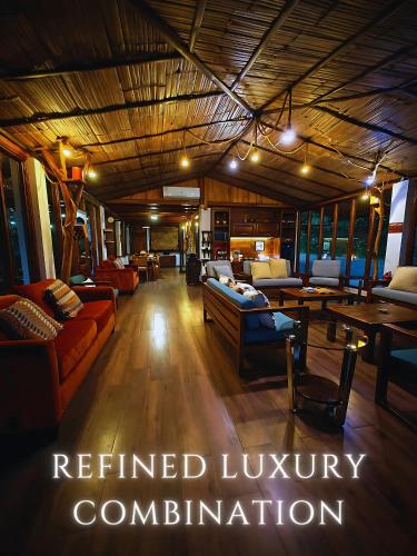 a living room with couches and tables in a room at The River House - Upscale Lodge in Puerto Quito
