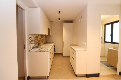 une cuisine avec des armoires blanches et une fenêtre dans l'établissement Paris Centre - Village Daguerre, Montparnasse, à Paris